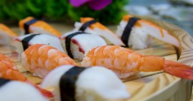 Yemek, seyahat ve sağlıklı beslenme konsepti. Japon suşisi bir restoranda öğle yemeği vakti, Asya mutfağı teslimatı. Karidesli suşi. 