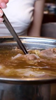 Yakın plan kızartma tavasında et suyu pilavı pilav vermicelli ve sebzeli kız Vietnam 'ı pişirmek için açık büfede yemeğini karıştırıyor. Vietnam çorbası pişir..