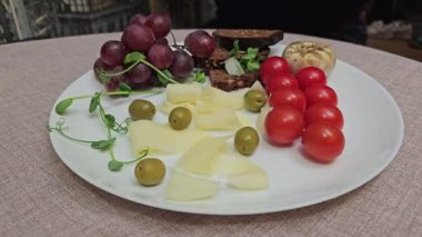 Üzüm, domates, yeşil zeytin, siyah ekmek, Provencal otlar, peynirli dilimler lüks otel kahvaltısı veren lezzetli bir restoranda. 4k