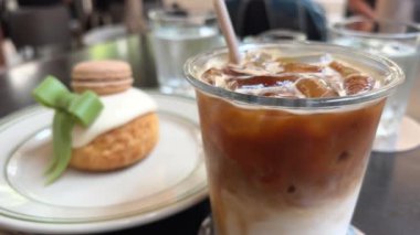 Atıştırmalık buzlu latte içer ve kremayla kaplı pasta pastası yer. Yanında yeşil fiyonklu blog kızı filmleri de var. Kahvaltılık restoran yürüyüşü, şehirdeki gerçek hayat. 4k 