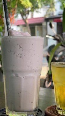 Masada Asya 'da yabani böğürtlenli kokteyl. Üç bardak yeşil çay, iki buzlu avokado ve böğürtlenli kokteyl. Yüksek kalite 4k görüntü