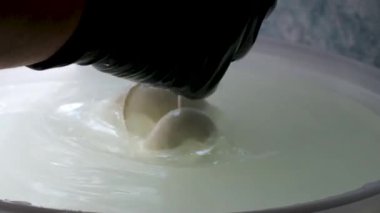 Süt ürünleri üretim hattı. Sanayi bölgesinde çalışan kadın fabrika işçileri peynirleri plastik poşete dolduruyorlar. Peynir fabrikası Mozzarella peyniri yapıyor.