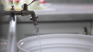 Su tasarrufu. Kadın bazı insanların suyu kapatmayı unuttuğunu buldu. Enerji tasarrufu için kullanmadıktan sonra suyu kapatmak ve tasarruf etmek küresel ısınmayı azaltır. Yüksek kalite 4k görüntü