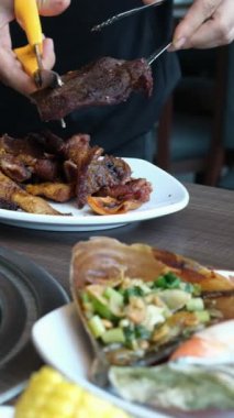 Vietnam mutfağı için ince kesilmiş et ve etli börekler makasla kesilmiş kızarmış tavuk. Adam yemek masasında kızarmış tavuğu mutfak makasıyla kesiyor..