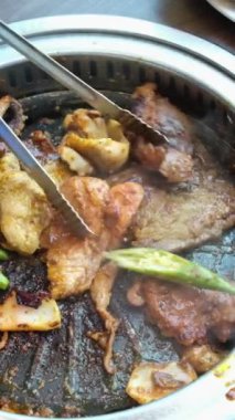 Vietnam mutfağı için ince kesilmiş et ve etli börekler makasla kesilmiş kızarmış tavuk. Adam yemek masasında kızarmış tavuğu mutfak makasıyla kesiyor..