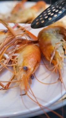 Sette Beyaz Tabakta Baharatlı Karides Tayland 'da Tayland Yemeğinin Ünlü Menüsü. Kırmızı Karidesler Pişirilmiş ve Sulama Suyu Altında Bir Colander Durulandırılmış