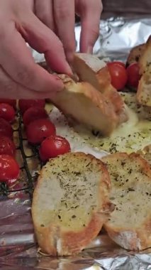 Norman Camembert 'in fırınına domatesli, Provencal otlu ve zeytinyağlı peynirini üç elle bandırıyorum. Yüksek kalite 4k görüntü