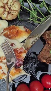 Zeytin, domates, salatalık, kekik ve limonlu siyah tavada ızgara halloumi peyniri. Doğu Akdeniz 'in geleneksel peyniri. Siyah arkaplan, seçici odak, yakın plan. 