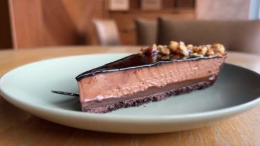 Çikolatalı tatlı peynirli kek tabakta, yakın plan. Cheesecake, tipik olarak süzme peynir, krem peynir, kuark veya ricotta, yumurta ve şekerle yapılan bir tatlıdır. Kabuğu olabilir.. 