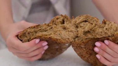 Tahta üzerinde taze buğday ekmeği yakın plan. Beyaz ekmek somununa basan kadın eli, tazelik kontrolü. Sağlıklı beslenme, doğal fırın ürünü. Yüksek kalite 4k görüntü