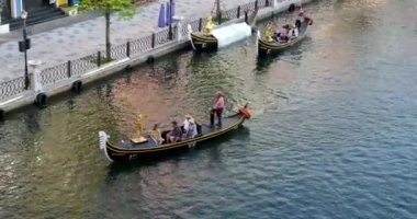 Büyük kanal nehri boyunca uzanan ünlü binalar ve oradan geçen bir gondol. Gondol Vietnam Phu Quoc Adası 06.15.2024