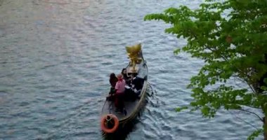 Büyük kanal nehri boyunca uzanan ünlü binalar ve oradan geçen bir gondol. Gondol Vietnam Phu Quoc Adası 06.15.2024