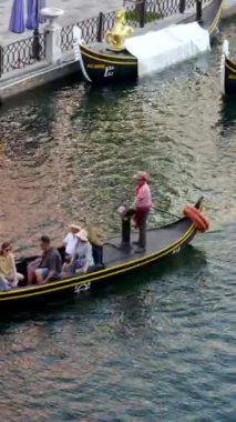 Büyük kanal nehri boyunca uzanan ünlü binalar ve oradan geçen bir gondol. Gondol Vietnam Phu Quoc Adası 06.15.2024