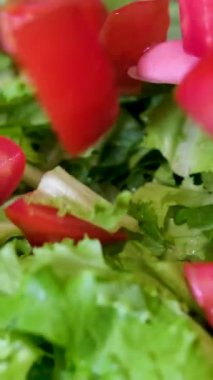 Şef salata yapraklarıyla kaseye doğranmış domates ekliyor taze salata hazırlıyor. marul yapraklarına domates ekle.