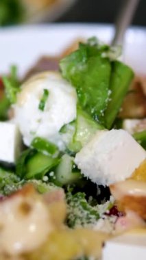 Çatalla Sezar salatası yemek. Tavuk fileto, marul, domates, bıldırcın yumurtası, kızarmış ekmek ve parmesan peynirinden yapılmış sağlıklı bir salata. Yüksek kalite 4k görüntü