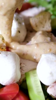 Sezar salatasını derin yemek kabının içinde pişirmek sos dökmek. Yüksek kalite 4k görüntü