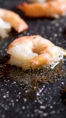 Karidesler yağlı tavada kızartılıp sarımsakla karıştırılır. Yakın plan. Yüksek kalite 4k görüntü