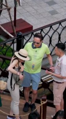 Phu Quoc Adası, Büyük Dünya, Vietnam, en son yerler. Şapkalı kadın suya giriyor. Çantasından bilet çıkarıyor. İnsanlar gondol turistik noktası Vietnam Phu Quoc 06.16.2024 'e biniyor.