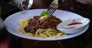 Kıyma ve domates soslu bolonez spagetti makarnasının üzerine dökülür. Yüksek kaliteli FullHD görüntüler