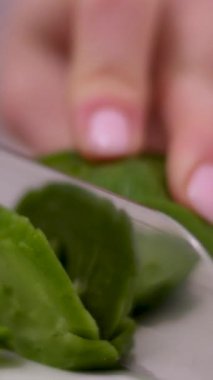 Peyniri ıspanakla kes. Kesme tahtasında yeşil peynir ve baharat var. Retro tonlu.