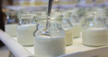 Süt veya yoğurt üreten fabrika plastik şişelere konveyör hattında. Süt ürünleri fabrikasındaki ekipman. Süt dolduruyorum. Seçici odak noktası süt şişeleme hattı. yoğurt fabrikası