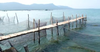 Balık çiftliği ahşap köprüsü okyanus Vietnam evi suyun üzerinde. Balık çiftliğinin güzel doğal manzarası. Turistik yerler 