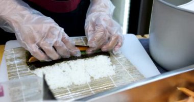 Taş siyah tahtada lezzetli Japon suşi ruloları. Çubuklar setten suşiyi alıp soya sosuna batırır. Kırmızı havyarlı, balıklı, Philly peynirli ve çubuklu çeşit çeşit suşi..