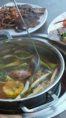 Tom Yam baharatlı çorba, karides, pirinç deniz ürünleri, hindistan cevizi sütü. Restorandaki geleneksel Asya mutfağını kapatın. Otlu çorba pişir.
