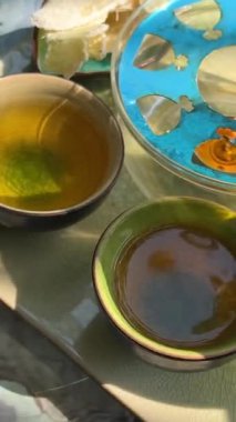 Beyaz çiçekli çay demleme işlemi, sıcak suda açılan güzel sarı çiçek, yeşil yapraklar, çay seremonisi. şeffaf cam çaydanlık. Mumlar yanıyor.