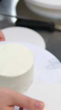 Bento keklerinin kremasını palet bıçağıyla düzleştiriyorum. Yakın plan. Web siteleri için tatlı, yemek fotoğrafı. Seçici odaklanma. Master sınıfı aşçılık okulunun tatlıları