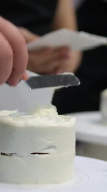 Palet bıçağı kullanarak, kremadan yapılmış bir çiçekle bento pastası süsle. Seçici odaklanma. Yüksek kalite 4k görüntü