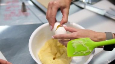 Pasta poşeti yardımıyla küçük ekler yapmak. Eklentiler için hamur borularını yavaş çekimde pişirme kağıdına döküyorum. Eklentiler için Choux hamur işi 