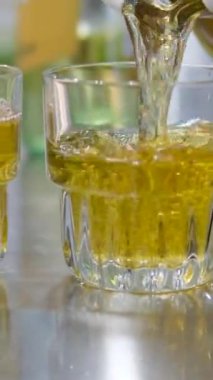 Elmalar arasında bir bardak meyve suyunun gölgesini gösteren güzel bir arka plan. Lezzetli aromatik elma suyu döküyorum. Yüksek kalite 4K görüntü. Bardakta elma suyu.