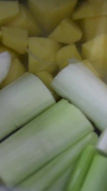 Geleneksel sebze çorbası, dilimler ve taze kesilmiş havuç, soğan, patates, kabak, kabak ve bezelye gibi sebzeler, sıcak buharla pişirilene kadar sıcak suda kaynatılır..