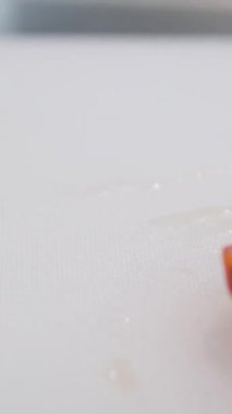 Kadın elleri bıçakla salata ya da yemek için vişneli domates kesiyor. Daldaki domatesleri delip geçti. Şef kiraz domateslerini takozlara klipsliyor. Yavaş çekim. 