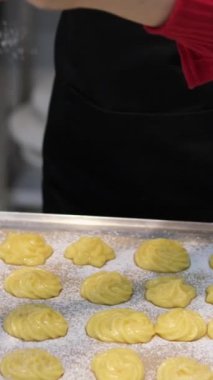 Profiterol üretimi süreci. Pasta poşetindeki hamur işlerini sıkıyorum. Kapatın. Yüksek kalite 4k görüntü