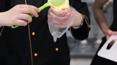 Profiterol üretimi süreci. Pasta poşetindeki hamur işlerini sıkıyorum. Kapatın. Hamuru hamur torbasına koy. Profiterol hamuru