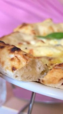 Peynirli bir dilim sıcak İtalyan pizzası. Fesleğenli dört peynirli pizza. Kadın dört peynirli fesleğenli peynirli pizza yiyor. Yüksek kalite 4k