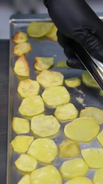 Kadın cam bir tabakta patates katmanına tavuk eti koyar. Evde yemek pişirmek. tavuklu patates graten.