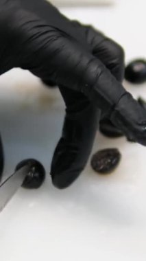Salata pişirirken siyah zeytinleri parçalara ayırır, siyah zeytinler öğütülür ve kesme tahtasının üzerinde parçalara ayrılır. Yüksek kalite 4k görüntü