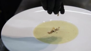 Ocakta kremalı sebze çorbası hazırlayan ve rendelenmiş çedar peyniri çırpan bir kadının kısa şarjörünü yap. Izgara peyniri sıcak sebze çorbasına ekliyorum.