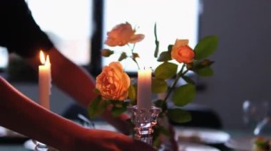 Noel yemeği mumlarını yaktı. Genç bir kadın romantik bir akşam yemeği için karısını beklerken mum yakıyor. Kız yıldönümü kutlaması hazırlıyor. Mutfaktaki masada romantik bir randevu.