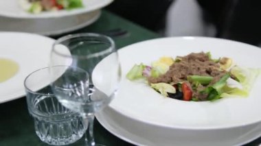 Ton balığı ve zeytinyağı sosu yap. Salata soslu ton balığı konservesi zeytinyağına sarımsak ve tuzla karıştırılır, bir kaseye karıştırılır ve salatanın üzerine dökülür. Yüksek kalite 4k görüntü