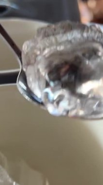 Yeşil arkaplana buz küpleri atın. Buz küplerine yakın çekim makro çekim, bardak içkisine dökülüyor. Yavaş çekim, 1000 fps boş bardaklara buz dolduruyor. Kamera el kamerasıyla canlı hareket ediyor. 