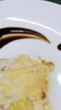 Masada parmesan peynirli fırınlanmış Fransız makarna mutfağı olan taze ızgaranın yakın ve seçici odağı servis edildi ve insanların elini gördü. tavuklu patates graten.