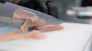 Kadınların ellerini kapat. Tavuk filetosu kes. Yemek hazırla. Tavuk eti masada. Yemek pişirmek. - Evet. Tavuk filetosunu kes.