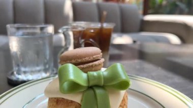 Makarnaların üzerine kocaman yeşil bir fiyonklu choux pastası. eklair kek Yüksek kalite 4K görüntü