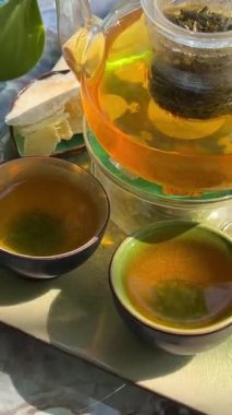 Geleneksel çay seremonisi sunumu. Şeffaf cam çaydanlıkta nefis bir iyileştirme çayı yapma sanatı. Bu sağlıklı içkinin her yudumunun dinlenme anı olduğu çay seremonisi. 