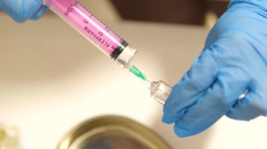 CU, şırınganın iğnesinden sıvı damlıyor şırınga yavaş çekimde güzellik enjeksiyonu. Estetik ameliyat. Yüksek kalite 