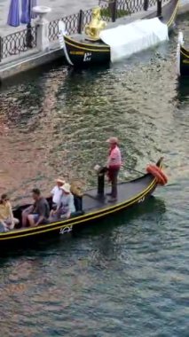 Büyük kanal nehri boyunca uzanan ünlü binalar ve oradan geçen bir gondol. Gondol Vietnam Phu Quoc Adası 06.15.2024